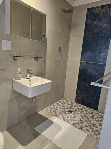 a bathroom with a sink and a shower at The Cottage Unit in Kathu