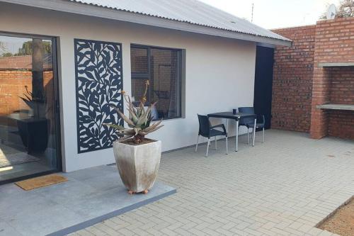 eine Terrasse mit einer Topfpflanze und einem Tisch in der Unterkunft The Cottage Unit in Kathu