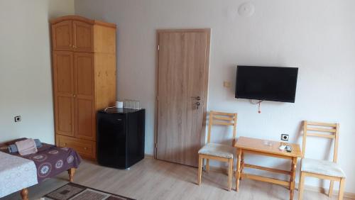 a living room with a bed and a television on a wall at Lora in Petrich
