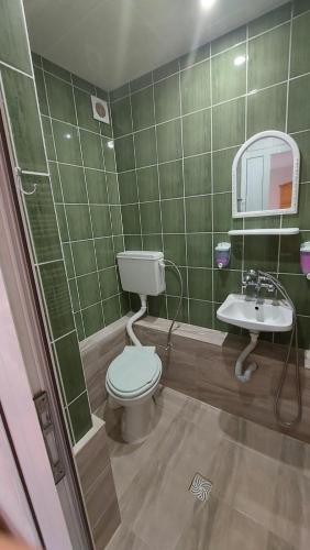 a green tiled bathroom with a toilet and a sink at Lora in Petrich