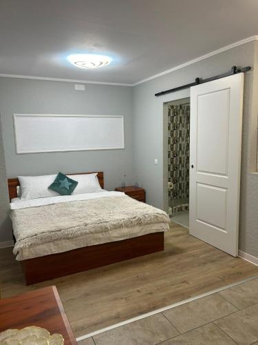 a bedroom with a bed and a white door at 4CENTER Apartments in Sibiu