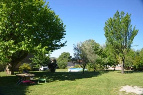 a park with a picnic table and chairs in the grass at Chez Germaine in Les Granges-Gontardes
