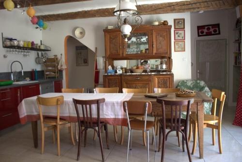 a kitchen with a wooden table and chairs at Chez Germaine in Les Granges-Gontardes