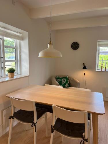 a dining room table with two chairs and a light fixture at Beach Guest House in Greve