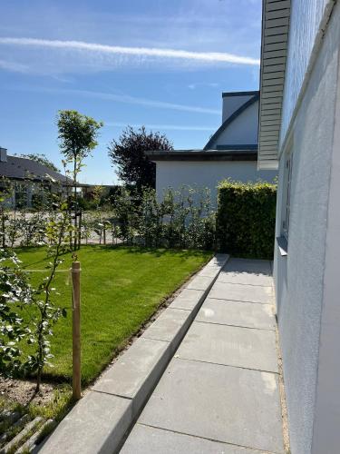 a sidewalk next to a house with a yard at Beach Guest House in Greve