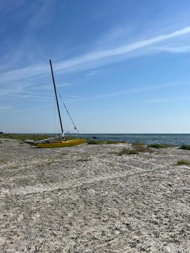 a yellow boat sitting on a beach near the ocean at Beach Guest House in Greve