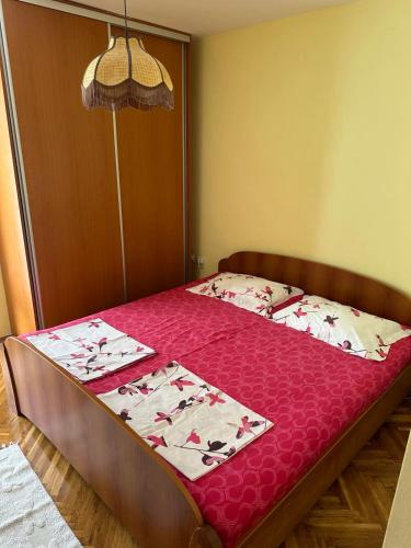 Un dormitorio con una cama con una colcha roja. en Sea View Budva, en Komoševina