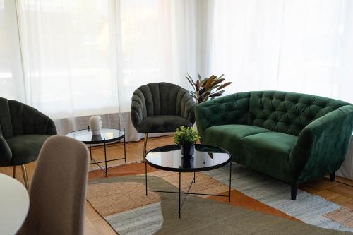 a living room with a green couch and two tables at NH 2 Interlaken-Luzern Lake I Mountain I unique I connect in Sachseln