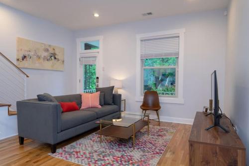 a living room with a gray couch and a tv at Modern 4BR Columbia Heights Gem Walk 2 Metro & Shops in Washington