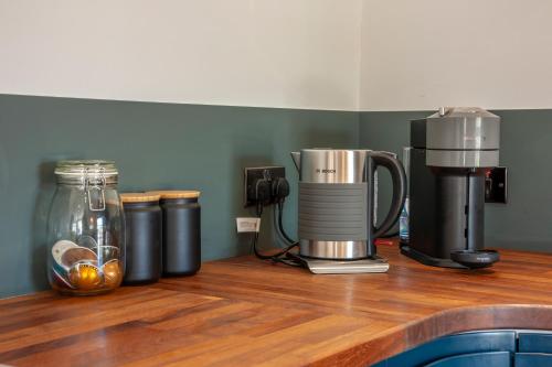 a counter with a coffee maker on a wooden counter top at Exceptional 2BD Apt - next to ferry & train station in Oban