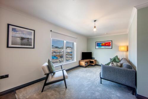a living room with a couch and a television at Exceptional 2BD Apt - next to ferry & train station in Oban