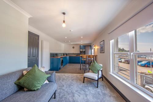 a living room with a couch and a large window at Exceptional 2BD Apt - next to ferry & train station in Oban