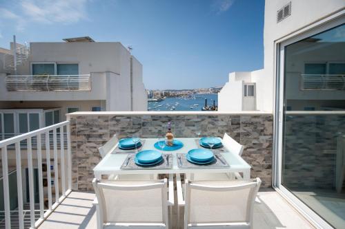 a white table and chairs on a balcony at Seaview Portside Penthouse SUPERIOR in St Paul's Bay