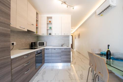 a kitchen with white cabinets and a counter top at Seaview Portside Penthouse SUPERIOR in St Paul's Bay