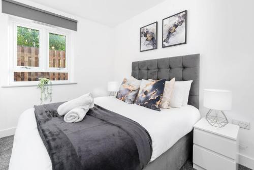 una habitación con una cama grande con sábanas y almohadas blancas en Two Bedroom Apartment - Balcony - Secure Parking - Top Rated - Underfloor Heating - 2MC, en Birmingham