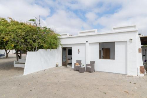 a white building with two chairs in front of it at Casita Lanzarote in Teguise