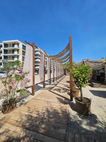 a wooden walkway on the beach with a hammock at Apartament modern 2 camere,complet utilat,cu balcon si Vedere la mare-Zoorba in Mamaia Nord