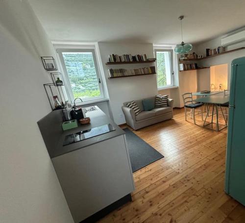 a kitchen and living room with a couch and a table at La Casa nella Vigna in Riva del Garda
