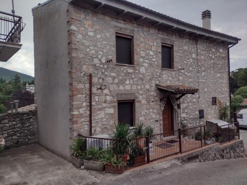 a stone house with a balcony in front of it at Viepri centro in Rocchette
