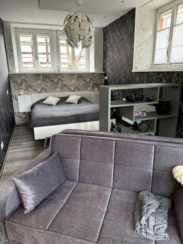 un salon avec un canapé et un lit dans l'établissement Au petit nid de Seebach, à Seebach