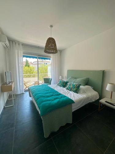 une chambre avec un grand lit avec une couverture bleue dans l'établissement Appartement plein centre, à Sainte-Maxime