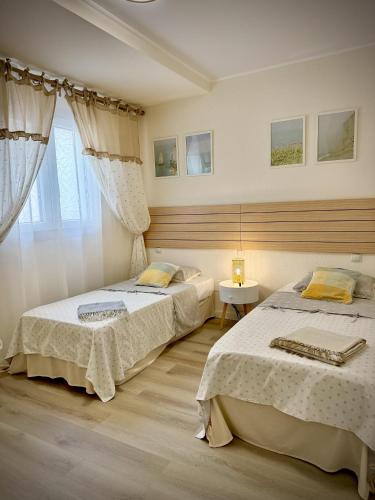a bedroom with two beds and a window at VVVHouse in Manilva