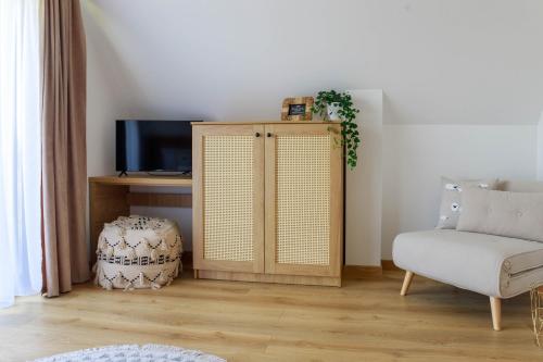 a living room with a cabinet and a chair at Ciwersówka Domki Białka Tatrzańska in Białka Tatrzanska