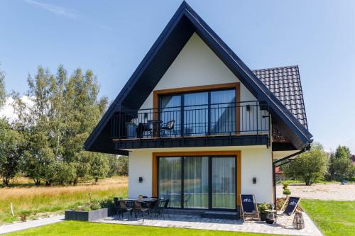 a house with a black roof at Ciwersówka Domki Białka Tatrzańska in Białka Tatrzanska