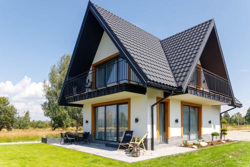 a house with a black roof at Ciwersówka Domki Białka Tatrzańska in Białka Tatrzanska