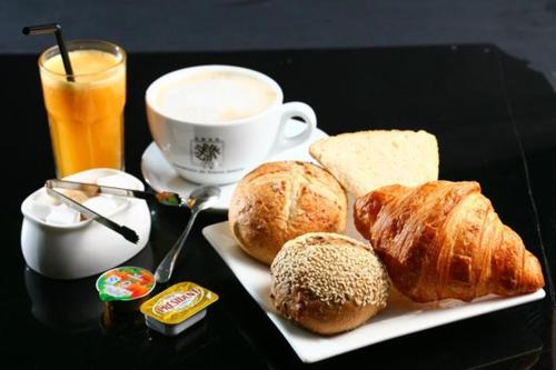 - une table noire avec un plateau de pâtisseries et une tasse de café dans l'établissement Bohème chic, à Faremoutiers