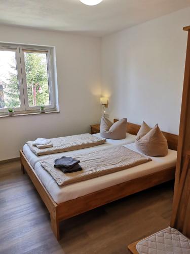 a large bed in a room with two windows at Apartment in Papstdorf "Zwillingsstiege" in Kurort Gohrisch