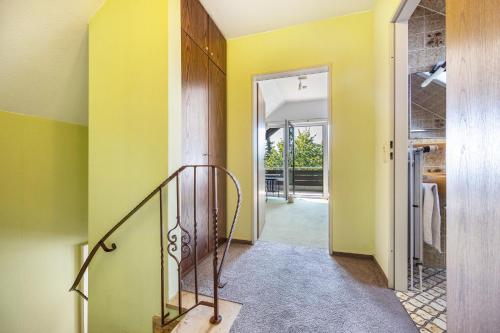 a hallway with yellow walls and a stairway at Ferienwohnung Hurlebusch Hahnenklee in Goslar