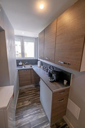 une grande cuisine avec des placards en bois et un évier dans l'établissement Le Cocon - Proche Gare Châteaucreux-, à Saint-Étienne