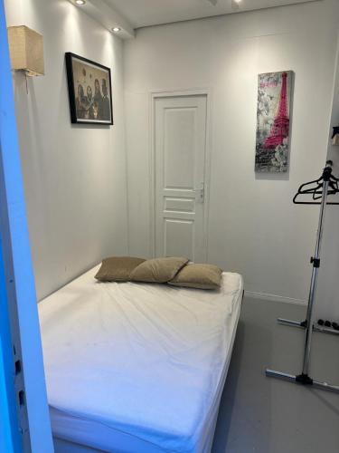 Cette chambre blanche dispose d'un lit et d'un tripode. dans l'établissement LOFT studio in zenithal light, à Paris