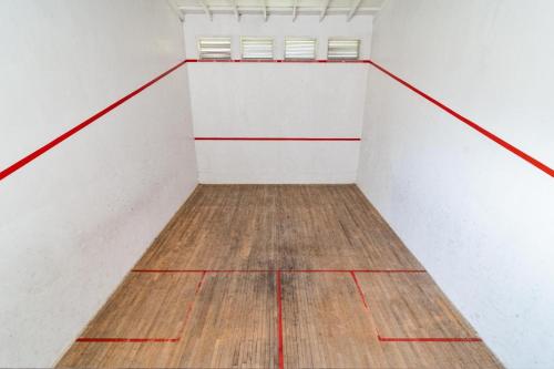 an empty basketball court with white walls and wooden floors at Chakas Rock Chalet 45 in Ballito