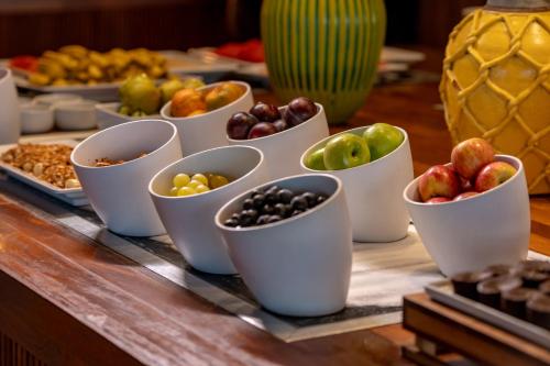 Jatiúca Suites Resort by Slaviero Hotéis في ماسيو: طاولة عليها أكواب مليئة بأنواع مختلفة من الفاكهة