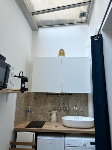 une petite cuisine avec un évier et un comptoir dans l'établissement LOFT studio in zenithal light, à Paris
