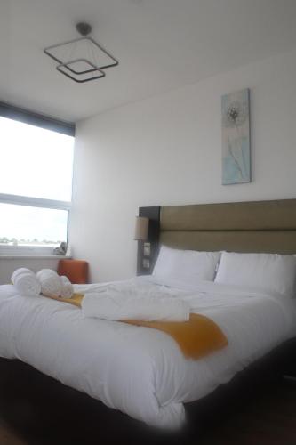 a bedroom with a large white bed with towels on it at Flat 413 One bedroom apartment in Birmingham