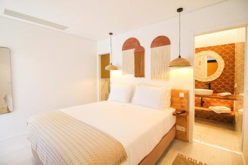 a bedroom with a large bed with white sheets at The Lost Garden in Vila Nova de Gaia