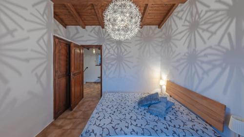 a bedroom with a blue bed and a chandelier at Brilago 1 in Brissago
