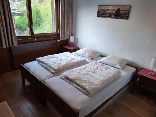 a bedroom with a bed with white sheets and pillows at Les Collons1800- Bel appart 2pièces-4 pers-piscine-sauna-parking int-Wifi gratuit in Vex