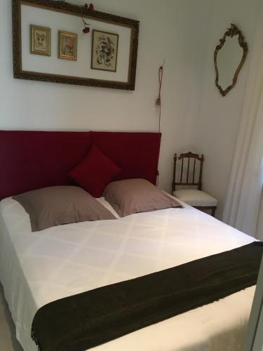 une chambre avec un grand lit avec une tête de lit rouge dans l'établissement Cannes congrès, à Cannes