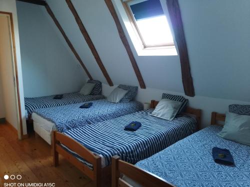 deux lits jumeaux dans une chambre avec fenêtre dans l'établissement Gîtes du GRC, à Campuac