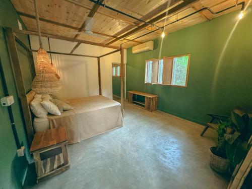 a bedroom with a bed in a room with green walls at KOMOREBI MADIHA in Madihe East