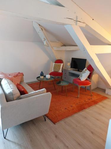 a living room with two chairs and a tv at ALEIDA in La Rochelle
