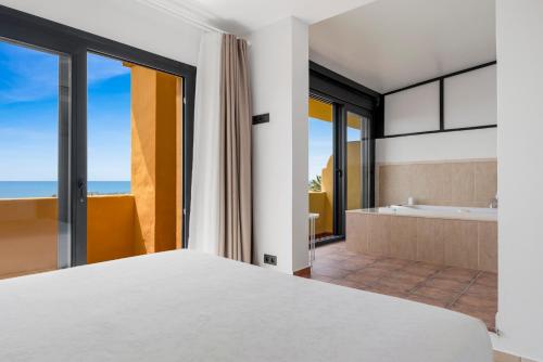 a bedroom with a bed and a bathroom with a tub at Sky And Sea Estepona Penthouse in Estepona