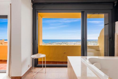 a bathroom with a tub and a view of the ocean at Sky And Sea Estepona Penthouse in Estepona
