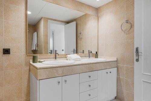 a bathroom with a white sink and a mirror at Sky And Sea Estepona Penthouse in Estepona