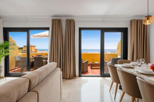 a living room with a couch and a table with chairs at Sky And Sea Estepona Penthouse in Estepona