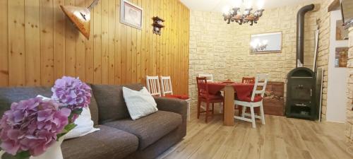 a living room with a couch and a table with a fireplace at ALLA CASCATA in centro Branzi self check-in parcheggio gratuito coperto in Branzi